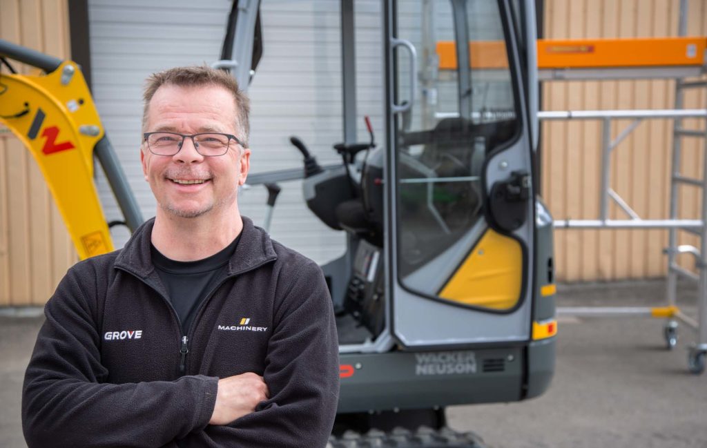 Juha Ojala minikaivinkoneen vieressä